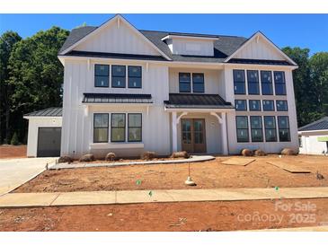 A Modern farmhouse with white siding, black trim and metal roof accents stands out at 1015 Kendall Dr # 4, Wesley Chapel, NC 28173