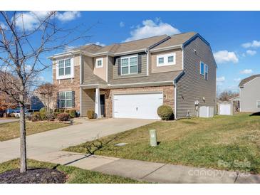 Two-story house with stone and siding accents, two-car garage, and landscaped lawn at 10436 Paisley Abbey Ln, Charlotte, NC 28273