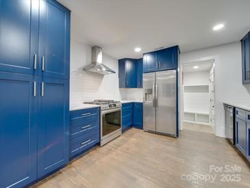 Modern kitchen with blue cabinetry, stainless steel appliances, and quartz countertops at 1330 Mulberry Ave, Charlotte, NC 28216