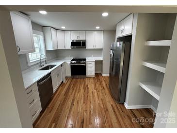 Bright kitchen features white cabinets, quartz countertops, stainless steel appliances, and hardwood floors at 112 Mccray Ave, Kannapolis, NC 28081