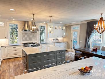 Gourmet kitchen boasts expansive island, stainless steel appliances, and white cabinetry at 13612 Robert Walker Dr, Davidson, NC 28036