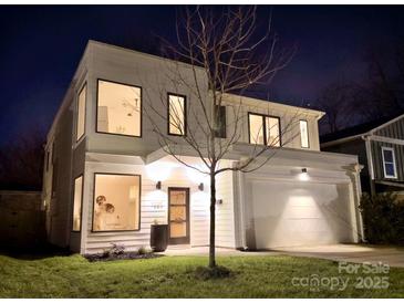 Stunning two-story modern home with a white exterior, large windows, and a two-car garage at 1220 Lomax Ave, Charlotte, NC 28211