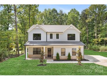 Two-story house with gray siding, a covered porch, and a landscaped lawn at 13114 Blacksmith Ct, Matthews, NC 28105