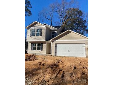 Two-story house with beige siding, a white garage door, and a partially landscaped yard at 1608 Cole St, Gastonia, NC 28054