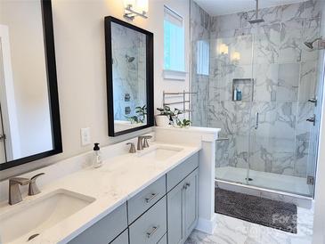 Modern bathroom featuring a dual sink vanity, a large walk-in shower with marbled tiles, and contemporary fixtures at 327 Coxe Ave, Charlotte, NC 28208