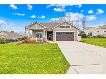 Curb appeal abounds in this charming ranch home boasting a 2-car garage and manicured lawn at 423 Granite Lake Ct, Denver, NC 28037