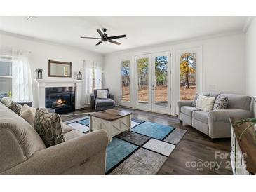 Spacious living room with fireplace, hardwood floors, and access to backyard at 4551 Selhurst Dr, Indian Land, SC 29707