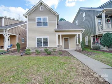 Tan two-story house with gray trim, a walkway, and a well-maintained lawn at 15334 S Birkdale Commons Pkwy, Huntersville, NC 28078