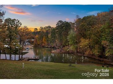 Scenic sunset view of lake with wooded shoreline and private dock at 51 Old Post Rd, Lake Wylie, SC 29710