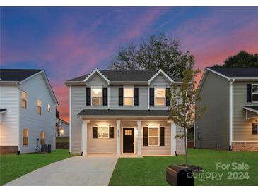 Two-story house with gray siding, a covered porch, and a well-maintained lawn at 8508 Sunflower Rd, Charlotte, NC 28227