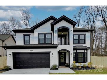 Beautiful two-story home with a black-and-white painted brick exterior, dark trim, and a two-car garage at 1308 Pleasant Plains Rd, Matthews, NC 28105
