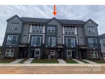 Modern townhome showcases gray siding, black brick accents, and a well-maintained lawn at 1316 Walter Taylor Way # Eqx0103, Charlotte, NC 28206