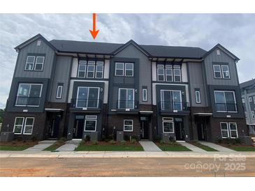 Modern townhome exterior features gray siding, brick accents, and a well-manicured lawn at 1320 Walter Taylor Way # Eqx0102, Charlotte, NC 28206