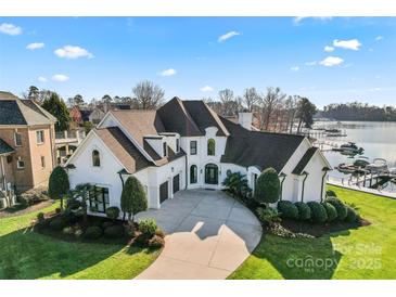 Stunning waterfront home with a circular driveway and manicured lawn at 18805 Flat Shoals Dr, Cornelius, NC 28031