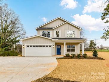 Charming two-story home boasts a blue front door, a spacious two-car garage, and a well-manicured front yard at 5613 Morgan Mill Rd, Monroe, NC 28110