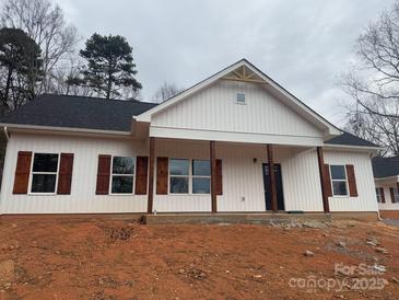 Charming single-story home with white siding, rustic wood shutters, and a welcoming front porch at 1306 Eddie St, Gastonia, NC 28054