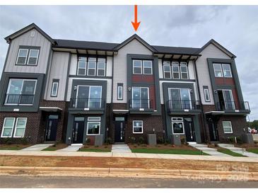 Modern townhome with brick facade, balcony, and neutral color scheme offers contemporary living at 1615 Polk St # Eqx0208, Charlotte, NC 28206