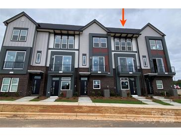 Newly constructed townhomes featuring modern architecture and a mix of brick and siding accents at 1619 Polk St # Eqx0207, Charlotte, NC 28206