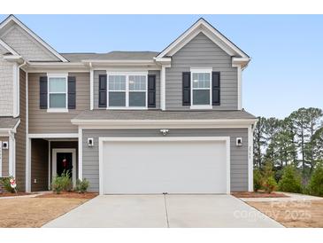 Two-story townhome with gray siding, white garage door, and landscaping at 2795 Yeager Nw Dr, Concord, NC 28027