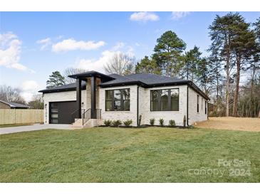 Modern brick home with a large yard and attached garage at 10614 Arlington Church Rd, Charlotte, NC 28227