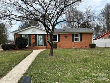 Brick ranch house with landscaped lawn and walkway at 5301 Hughes Dr, Charlotte, NC 28213