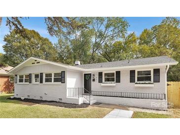 Charming ranch home with white brick exterior, black shutters, and landscaped lawn at 5442 Kinsale Ln, Charlotte, NC 28215