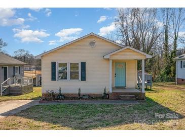 Charming yellow house with a light teal front door and well-maintained landscaping at 222 E Alabama Ave, Bessemer City, NC 28016