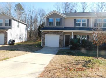 Two-story townhome with stone accents and a driveway at 274 Village Creek Way, Salisbury, NC 28147