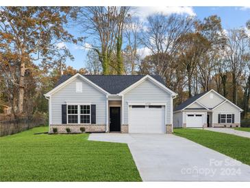 Newly constructed home with gray siding, two-car garage, and well-manicured lawn at 5513 Skycrest Dr, Charlotte, NC 28269