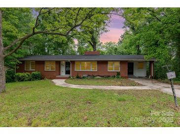 Charming single-story brick home featuring a spacious front yard and mature trees offering ample shade at 203 Azalea Rd, Lancaster, SC 29720