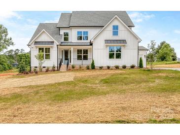 Stunning two-story home with board and batten siding and a well-manicured lawn at 320 Triple Ponds Ct, Clover, SC 29710