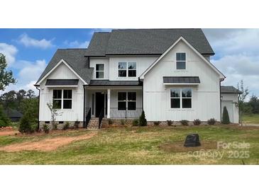 Stunning two-story home featuring a modern farmhouse design with a manicured lawn and welcoming entrance at 320 Triple Ponds Ct, Clover, SC 29710
