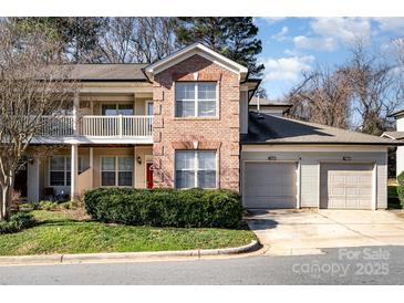 Brick front exterior of charming townhome with attached two-car garage and well-manicured lawn at 7333 Michaels Landing Dr, Charlotte, NC 28262