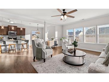 Open living room featuring hardwood floors and a view into the kitchen at 188 Water Ski Dr, Statesville, NC 28677