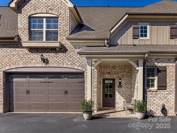 Brick front exterior of townhome with 2-car garage, covered entry, and landscaping at 3364 Northampton Dr, Charlotte, NC 28210