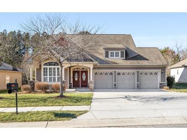 Two-story house with a three-car garage and manicured lawn at 500 Planters Way, Mount Holly, NC 28120