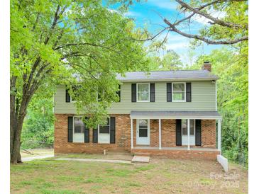 Charming two-story home featuring brick accents, black shutters, and a welcoming front porch at 9106 Nash Ave, Charlotte, NC 28213