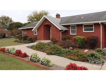 Brick ranch home with landscaped gardens and walkway at 129 Ann St, Salisbury, NC 28146