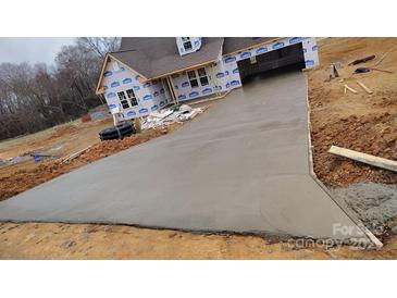 Long concrete driveway leading up to a partially-constructed home at 184 Maplewood Ln, Taylorsville, NC 28681