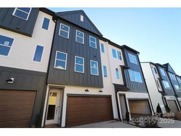 Modern 3-story townhome with dark gray and white exterior, 2-car garage, and landscaping at 7932 Cedarsmith Ct, Charlotte, NC 28217