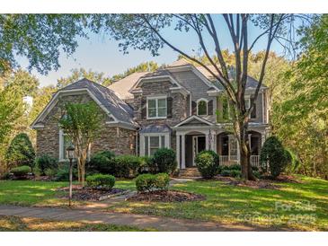 Two-story stone and shingle house with landscaped lawn and mature trees at 9042 Summer Club Rd, Charlotte, NC 28277