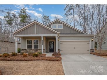 Charming single-Gathering home with a well-manicured lawn, attached garage, and inviting front porch at 14509 Batteliere Dr, Charlotte, NC 28278