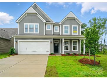 Charming two-story home with gray siding, a two-car garage, and a well-manicured lawn at 5404 Verona Rd # 36, Charlotte, NC 28213