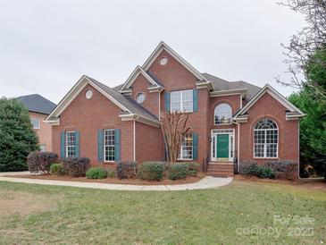 Brick two-story house with a green door and landscaping at 810 Carisbrooke Ln, Waxhaw, NC 28173