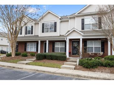 Tan and brick townhome with covered porch and landscaping at 2856 Summergrove Ct, Matthews, NC 28105