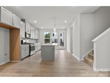 Beautiful, modern kitchen with gray cabinets, island, stainless steel appliances, and eat in space at 1750 Blanche St, Charlotte, NC 28262