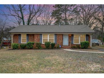 Brick ranch house with landscaped lawn and walkway at 4201 Westridge Dr, Charlotte, NC 28208