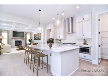 Bright kitchen features an island with marble countertop, modern appliances, and pendant lighting at 1374 Cedardale Ln # 33, Denver, NC 28037