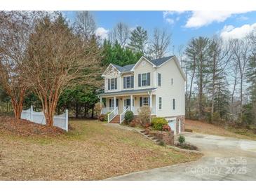 Two-story house with a brick-and-vinyl exterior, a white picket fence, and a spacious yard at 119 Heritage Creek Dr, Hickory, NC 28601