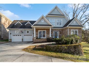 Two-story house with stone and gray siding, two-car garage, and landscaping at 2717 Madison Oaks Ct, Charlotte, NC 28226